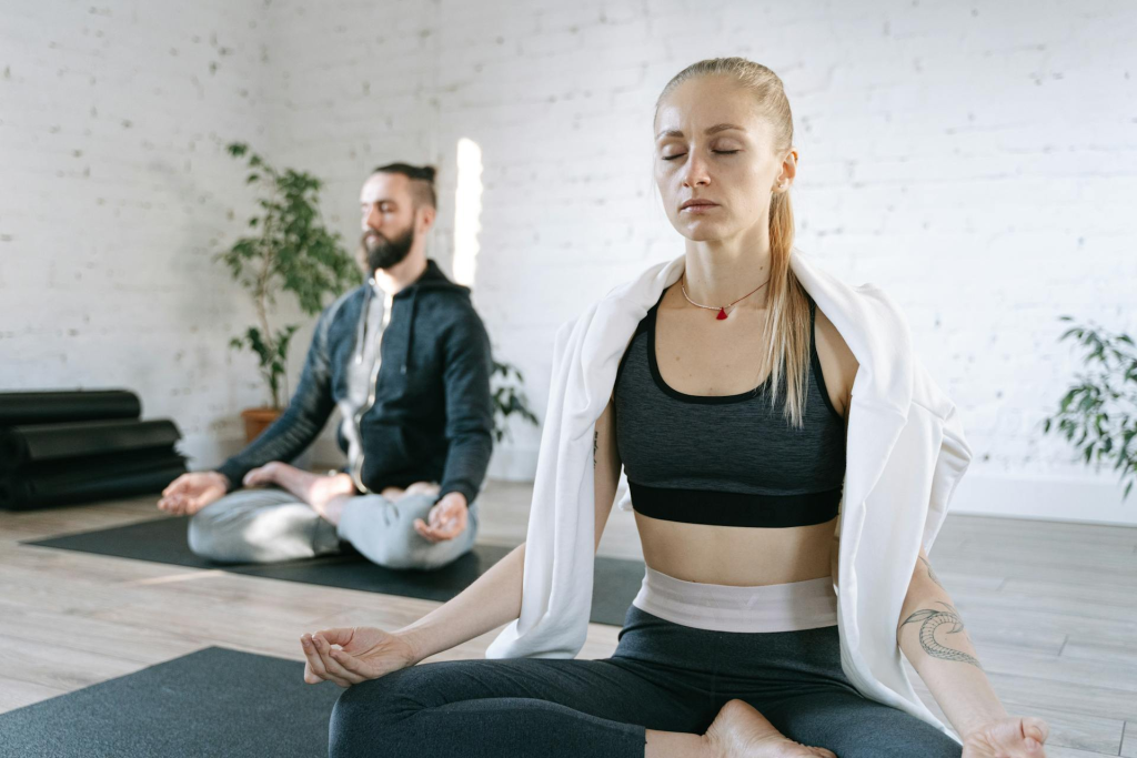 a men and a woman doing yoga in a peaceful studio